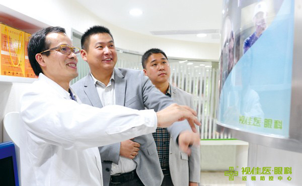 陈庆丰（左）为万新光学销售总监焦飞宏（中）及大区经理李春荣（右）详细讲解由其独创的“儿童三助护眼系统”